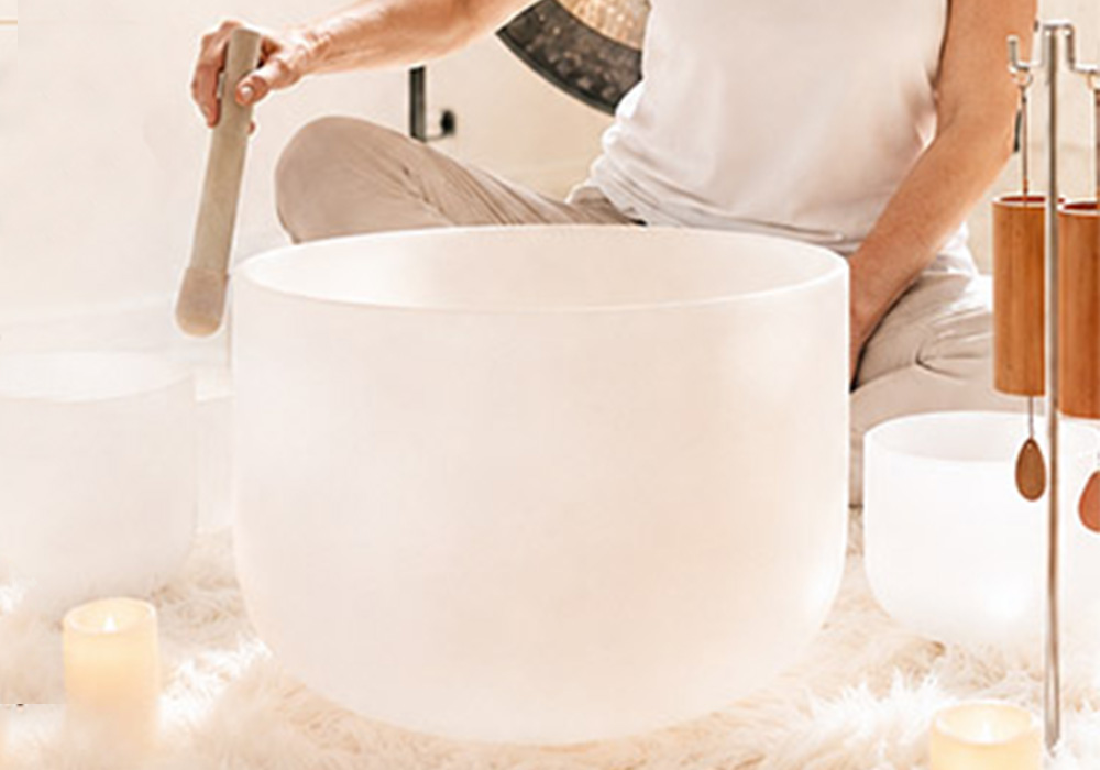 Terry playing her singing bowl at a soundbath experience 